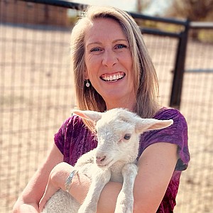 Coreen Walson holding a lamb in her arms.